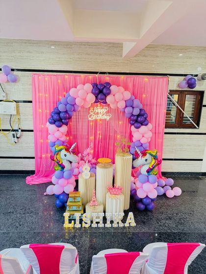 A wider shot of the unicorn theme party, showing the setup in the context of the room with guest chairs in the foreground. I can adapt my decorations to fit any party space.