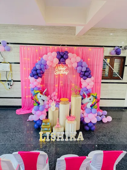A wider shot of the unicorn theme party, showing the setup in the context of the room with guest chairs in the foreground. I can adapt my decorations to fit any party space.