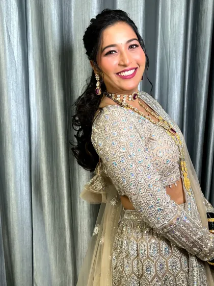 A side profile showing the elegant hairstyle and the beautiful smile of the bride in her reception attire.