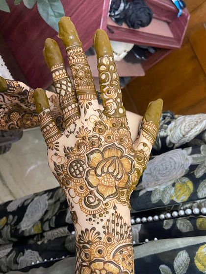 A close-up of one palm, highlighting the central flower and finger details.