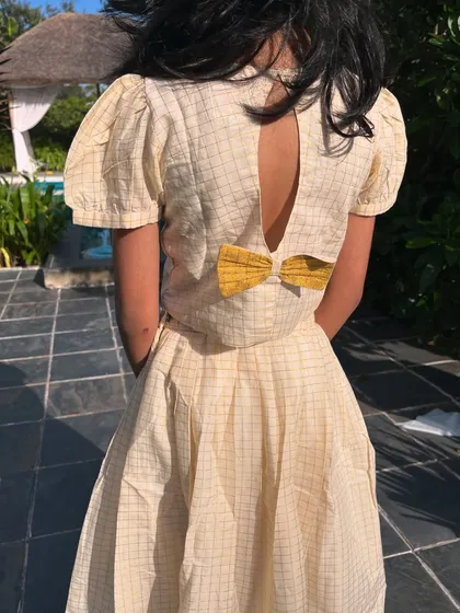 A peek at the back of our checkered two-piece set, featuring a sweet bow detail. It’s these little surprises that make an outfit special.