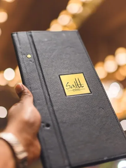 A guest holds up our custom menu against the backdrop of a grand, beautifully lit event. Every element is designed to create a cohesive and luxurious experience.