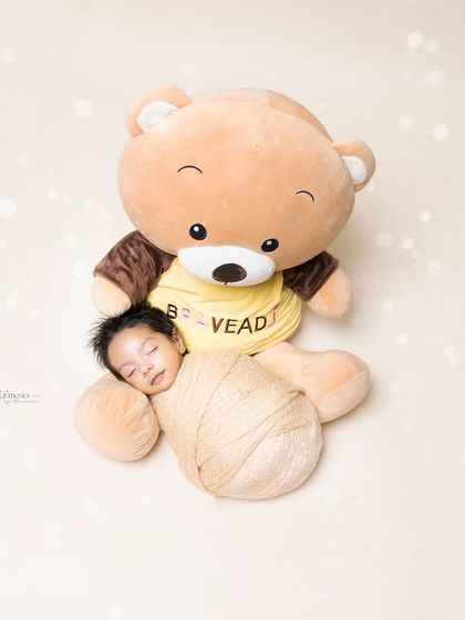 Napping like a boss, cuddled up with a giant teddy bear. This adorable and playful shot is perfect for capturing a sweet, sleepy moment.