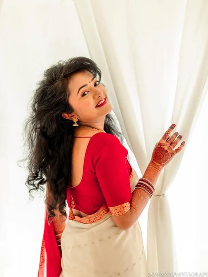 A bright and airy bridal portrait. The bride looks over her shoulder with a beautiful smile, her hair flowing freely.