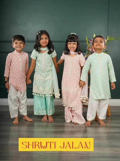 Four friends, two perfect sibling pairs. The girls' sharara sets and the boys' kurtas are coordinated in soft pink and mint green for a beautiful group photo.