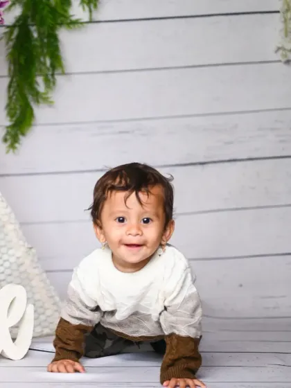 A happy baby crawling towards the camera during their milestone session.