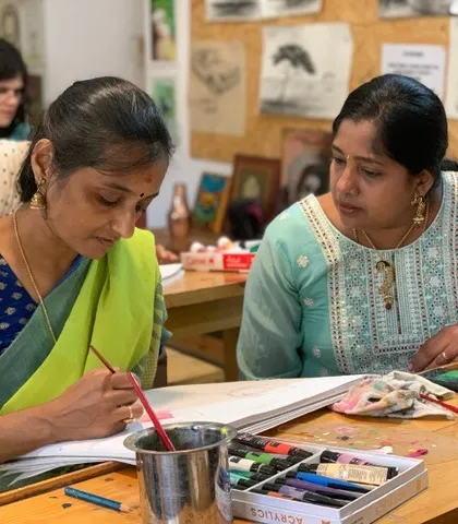 An instructor provides feedback to a student working on an acrylic painting. This constant loop of practice and guidance is how we help artists build confidence and skill.