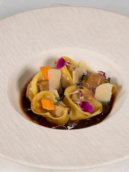 Our handmade tortellini, filled with savoury ingredients and served in a rich broth. Each piece is a small parcel of flavour, garnished with edible flowers.