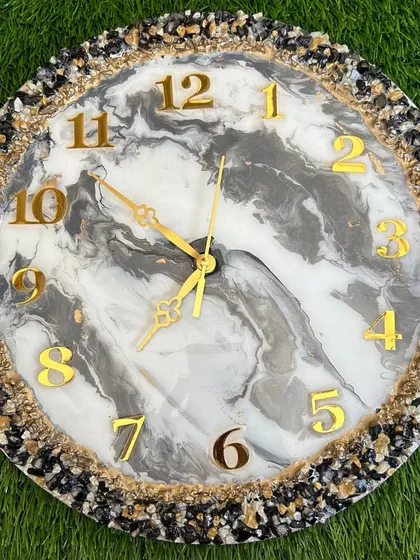 A stunning clock with a black and white marble effect and a full border of coordinating stones.