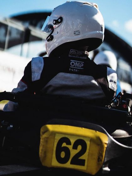 A rear view of a driver in his kart, ready on the grid.