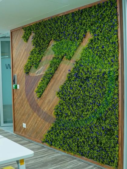 Here is a custom-framed moss wall featuring a logo cutout, blending wood and preserved moss. This is a great example of how we can integrate a company's brand directly into a biophilic art piece for a unique and memorable feature.