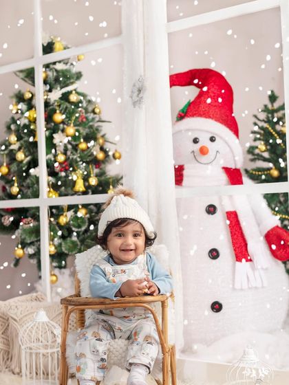 A happy baby enjoying the magical snowfall in our winter wonderland studio. A perfect moment of Christmas wonder.