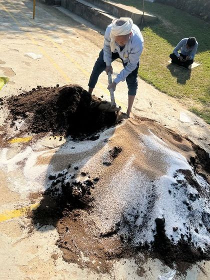We believe in using the best ingredients for our soil. A team member is seen here mixing a large batch of our custom potting soil, ensuring consistent quality for every project.