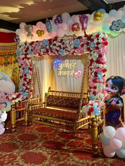 Another angle of the traditional swing decoration for a baby shower, showing the placement of Radha Krishna and baby cutouts.