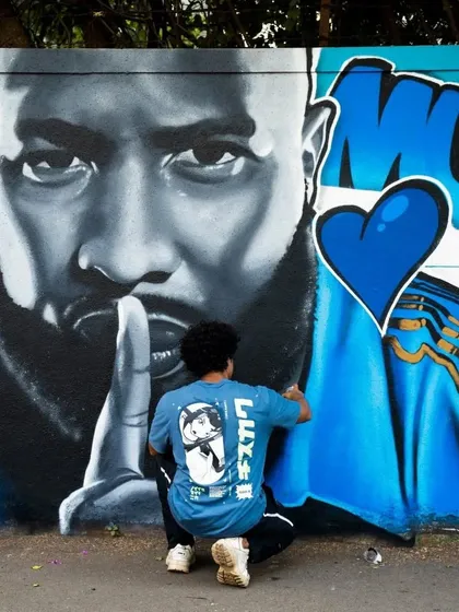 The process of creating a large-scale portrait requires immense precision. This shot shows the artist adding the final touches to the mural for the Mumbai Indians.
