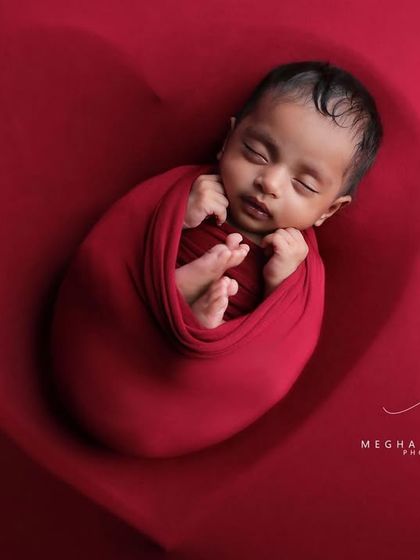 A close-up on the baby's face, showing their serene expression while nestled in the heart. This is a perfect example of a timeless newborn portrait.