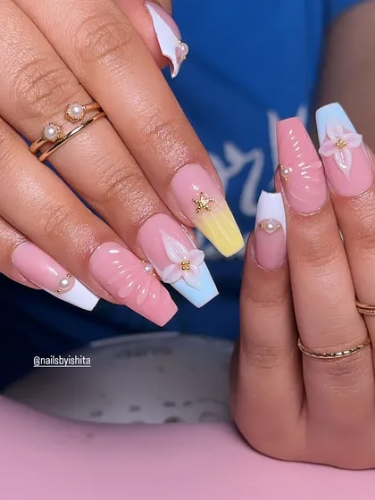 Perfect vacation nails. This summery set features a colorful pastel ombre, 3D flowers, and seashell-inspired textures.
