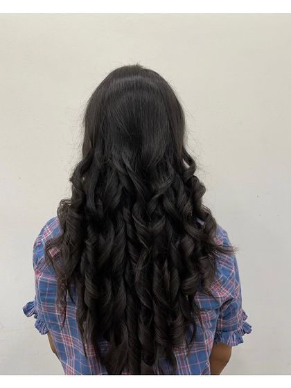 An example of our styling services. This client's long, dark hair has been styled into perfect, uniform curls for a glamorous and polished look.
