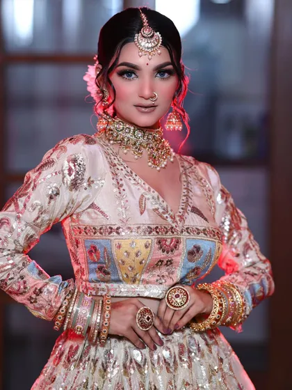 A modern bridal look with a pastel multi-color lehenga. The makeup is kept nude and glowy with a pop of glitter on the eyes.