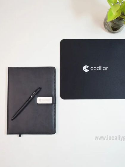 A simple and effective branding solution. This set for Codilar includes a custom mousepad and a matching black notebook with a pen, keeping the brand visible on the desk.
