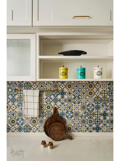 The kitchen embodies a Moroccan-Scandinavian theme with a color scheme of royal blue and ivory. The backsplash features vibrant Moroccan tiles, adding a pop of pattern and color.