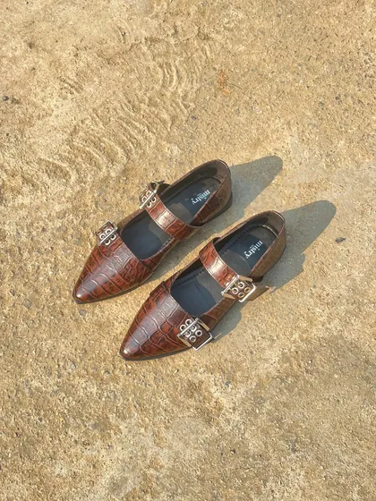 My new bestseller, the buckled ballet flat in a rich, brown croc-embossed leather. The texture of the leather combined with the silver hardware creates a shoe that feels both luxurious and modern.