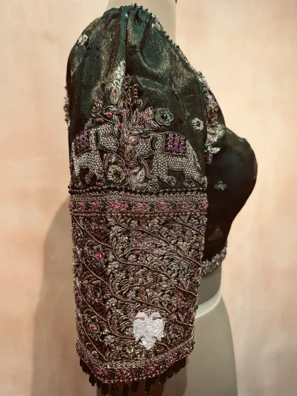 I love playing with rich colors and traditional motifs. This Eden green tissue brocade blouse features majestic elephants on the sleeves, detailed with fine threadwork and bead accents. It's a perfect blend of regal aesthetics and detailed artistry.