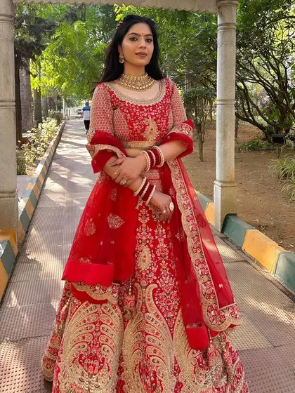 Radiating elegance in a classic red lehenga. For this North Indian bridal style, I created a sophisticated look with soft, flowing hair and makeup that highlighted her features, ensuring she looked and felt like royalty on her big day.