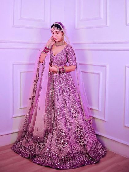 This heavily embroidered lilac lehenga is fit for a princess. The mirror work and intricate patterns make it a luxurious choice for a sangeet or reception.