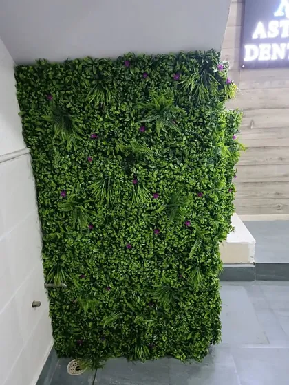The artificial green wall installed under a staircase in a commercial building. It transforms a purely functional area into a decorative feature.