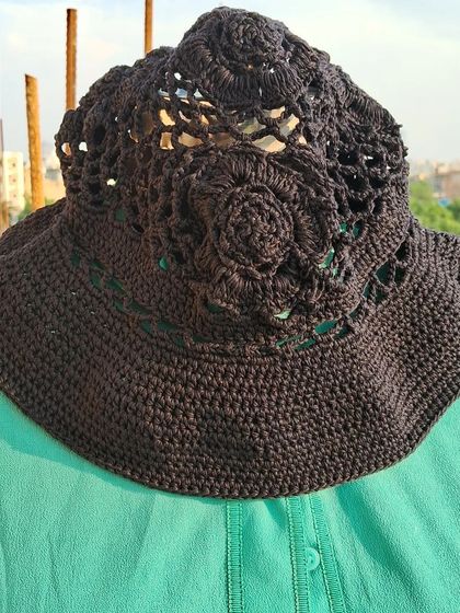 A top-down view of the crochet bucket hat, revealing the beautiful floral-inspired pattern on the crown. It's these little details that make our handmade pieces so special.