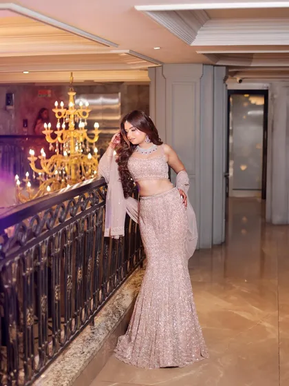 A full-length shot that captures the elegance of the mermaid gown and the grandeur of the venue's chandelier. I focus on composition to ensure both the outfit and the setting shine.
