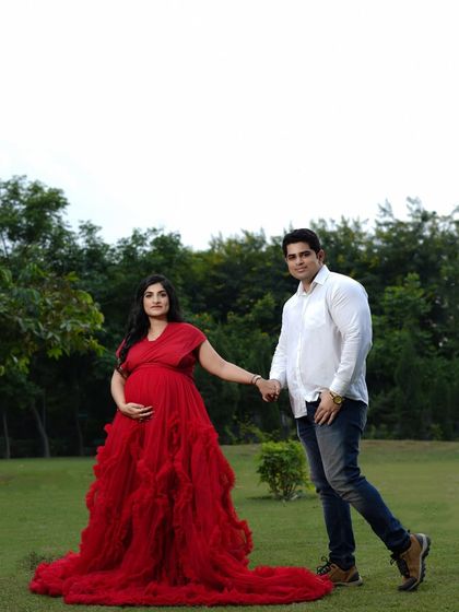 Walking hand-in-hand towards their future. This outdoor portrait in a lush green park symbolizes their journey together as they step into parenthood.