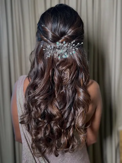 The hairstyle is just as important as the makeup. For this look, we went with soft, romantic waves in a half-up style, adorned with a delicate hair accessory. This hairstyle for bridesmaids complements the soft glam makeup perfectly.