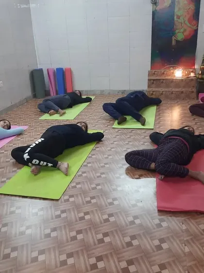 The class is in a supine spinal twist, a restorative pose that helps release tension in the back and improve digestion. We always end with cooling down.