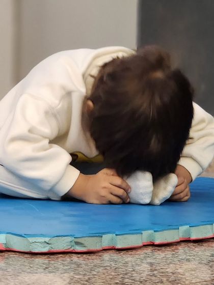 A candid shot of a toddler deeply focused on a stretch. These moments of quiet concentration are just as important as the high-energy dance moves.