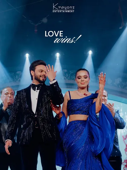 "Love wins!" The couple takes a bow on stage after a fantastic performance, surrounded by applause and bright lights. A perfect end to a memorable act.