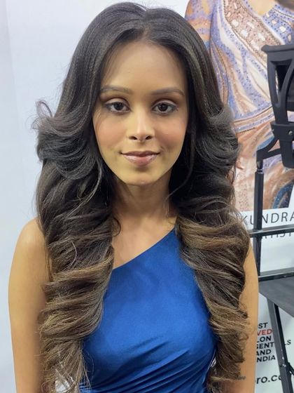 Another angle of the voluminous curls, showing the soft texture and movement in the hair.