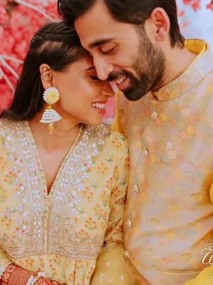 An intimate close-up of the couple. Their genuine smiles and gentle embrace show the comfort and happiness they find in each other.