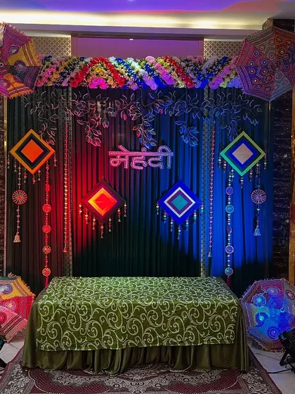 The same Mehendi stage illuminated with red and blue lights, showing how we can customize the lighting to match the mood of the function.