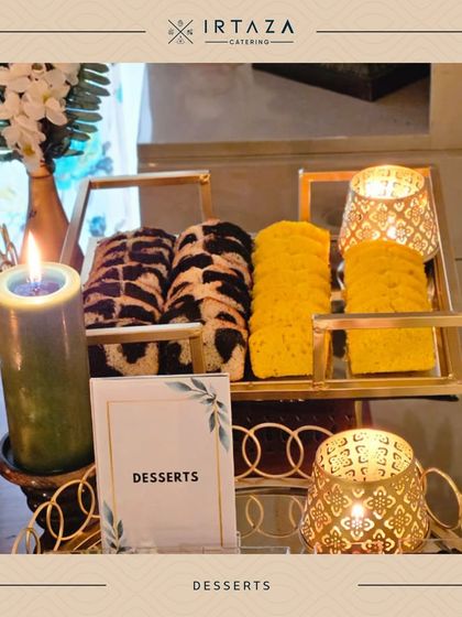 A beautiful display of desserts, including marble cakes and lemon pound cakes, set amidst glowing candles for a warm and inviting dessert corner.