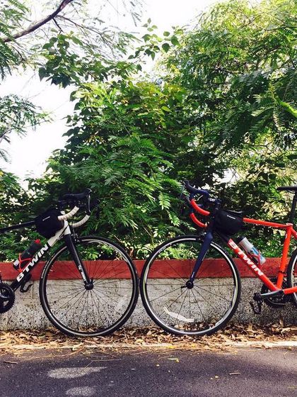 Two Btwin Triban road bikes, the perfect machines for a challenging climb like Nandi Hills, resting side-by-side.