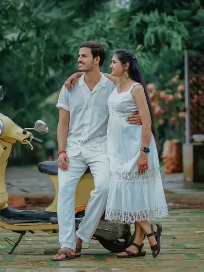 A sweet moment from a vintage-themed shoot. Om Prakash has his arm around Suchita as they pose with a yellow scooter, creating a charming, old-school romantic vibe.
