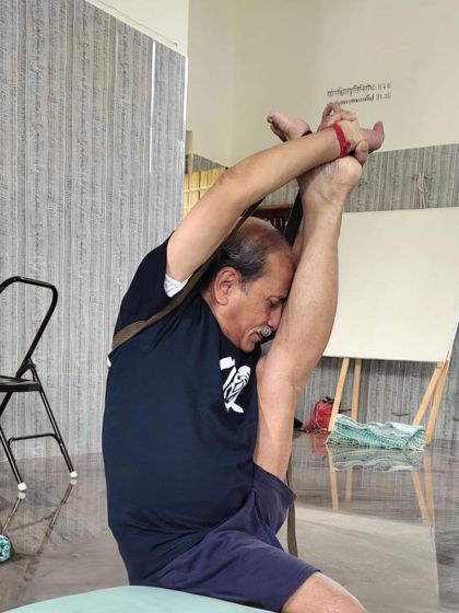 A deep standing forward bend variation, bringing the leg up towards the head. This pose demonstrates extreme flexibility in the hamstrings and spine.