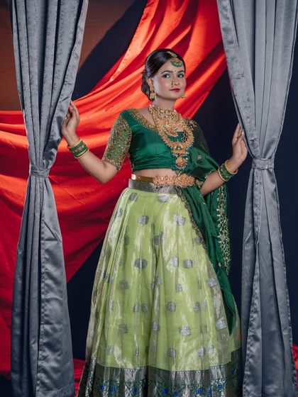 A dramatic pose with curtains, this full-length shot shows the flow of the lehenga and the grandeur of the jewellery.