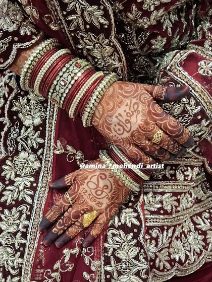A stunning shot of the final stain, complemented by the bride's red dress and bangles. The design includes the date and initials.