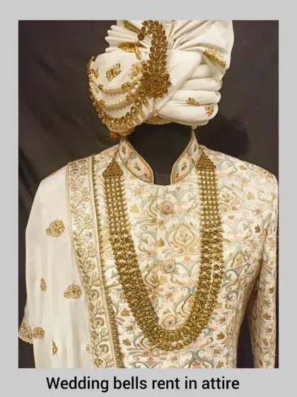 A close-up of our classic ivory sherwani, showcasing the intricate gold embroidery and the matching pagri.