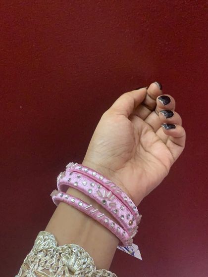 A collection of my pink silk thread bangles, showcasing a variety of designs from simple geometric patterns to elaborate floral kundan work.