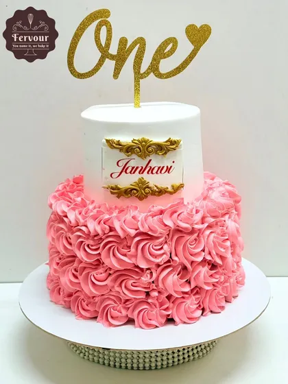 First birthdays are always special. This two-tier chocolate truffle cake features a beautiful rosette piping design on the bottom tier and a personalized name plaque.