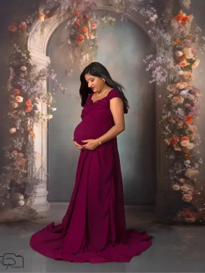 A moment of quiet connection with her baby. This mama gently holds her bump, her expression full of love and anticipation.